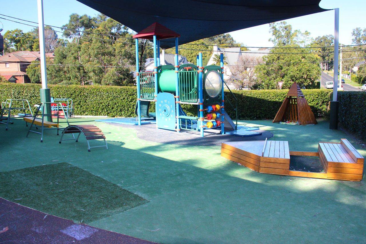 The outdoor playground at West Ryde Long Day Care Centre, with a climbing structure under shade sails