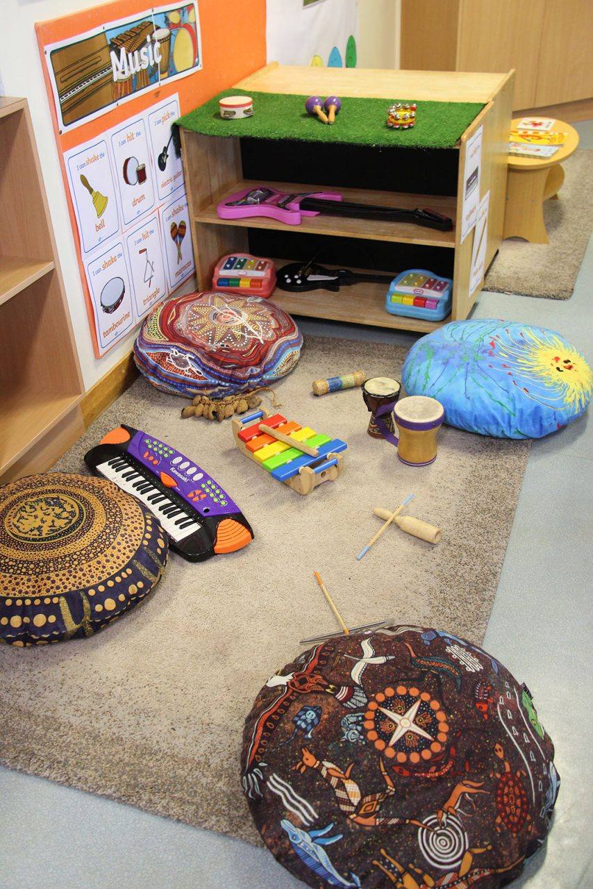 The Rainbow Room music corner with instruments and Indigenous-themed cushions